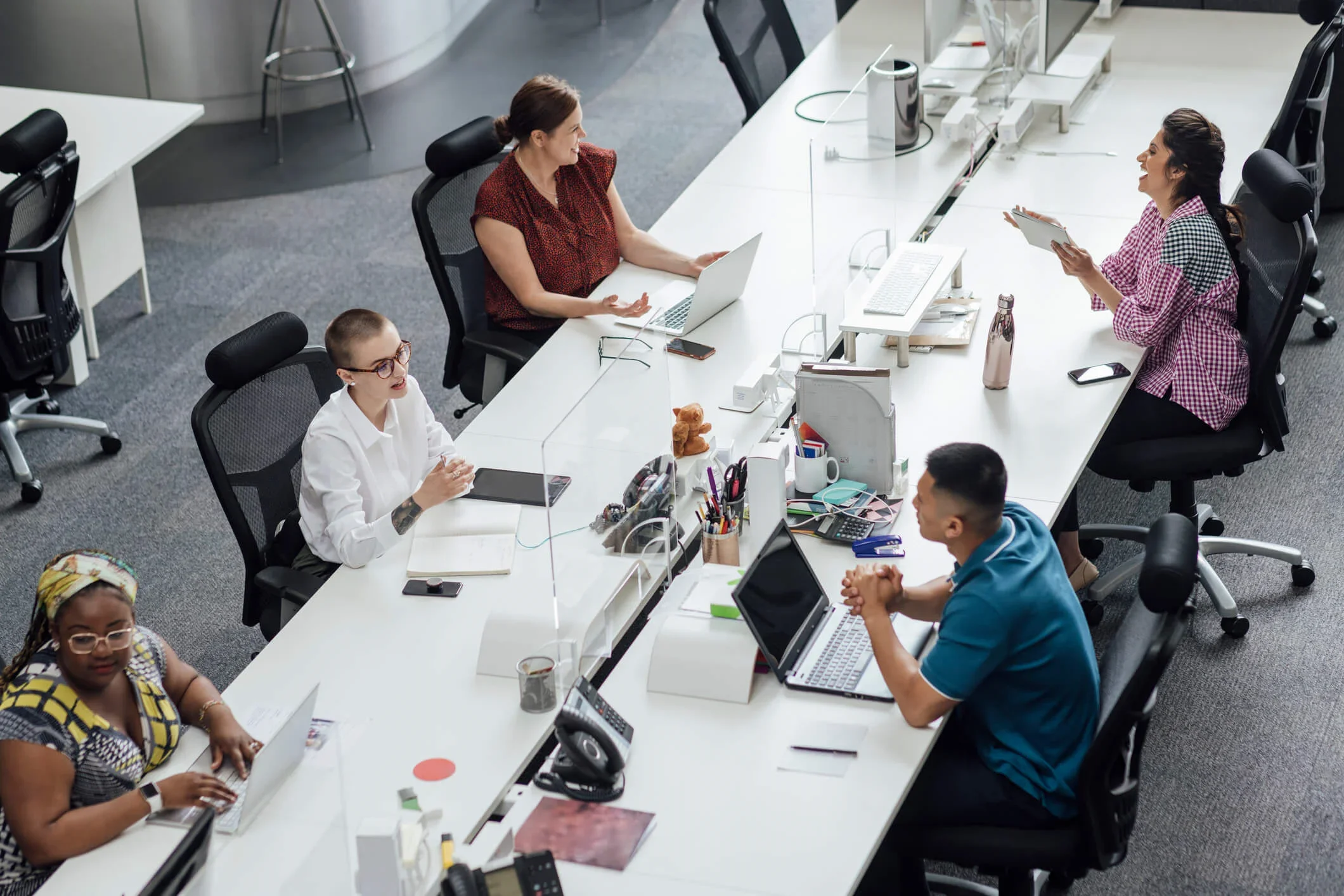 A group of people sitting at a long table in an office